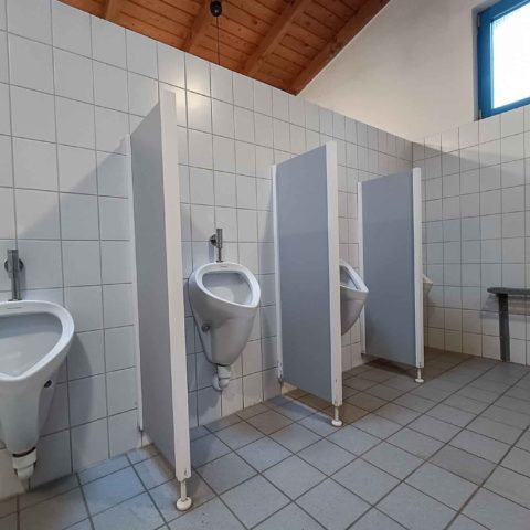 Vue intérieure des urinoirs dans le bâtiment sanitaire 1 du camping pour jeunes Hauenstein.